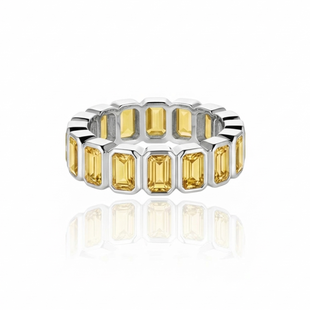 White gold eternity ring with yellow sapphires set vertically, in individual bezels; ring is presented on a white background