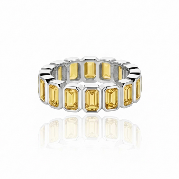 White gold eternity ring with yellow sapphires set vertically, in individual bezels; ring is presented on a white background