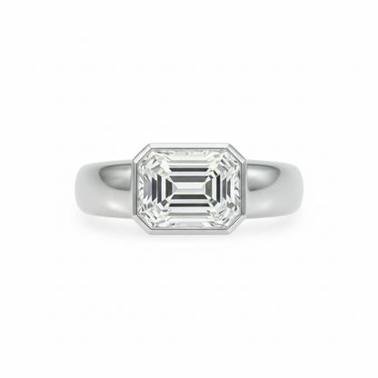 White gold ring with a large emerald-cut diamond, bezel set, east-west, laterally set, chunky band; the ring is shown on a white background