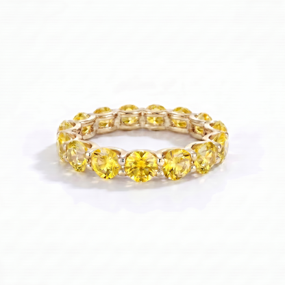 Eternity yellow gold ring with yellow sapphires on a white background