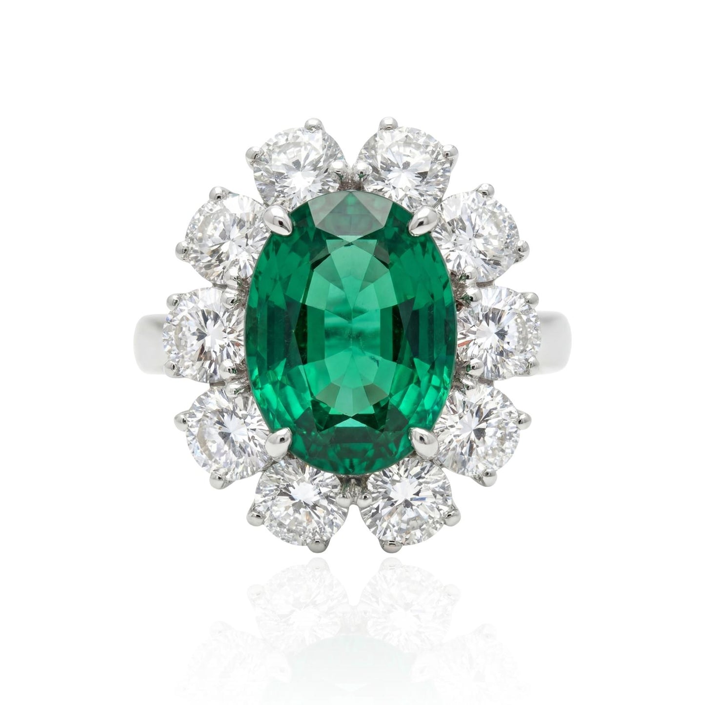 Emerald white gold ring with diamond accents on a white background