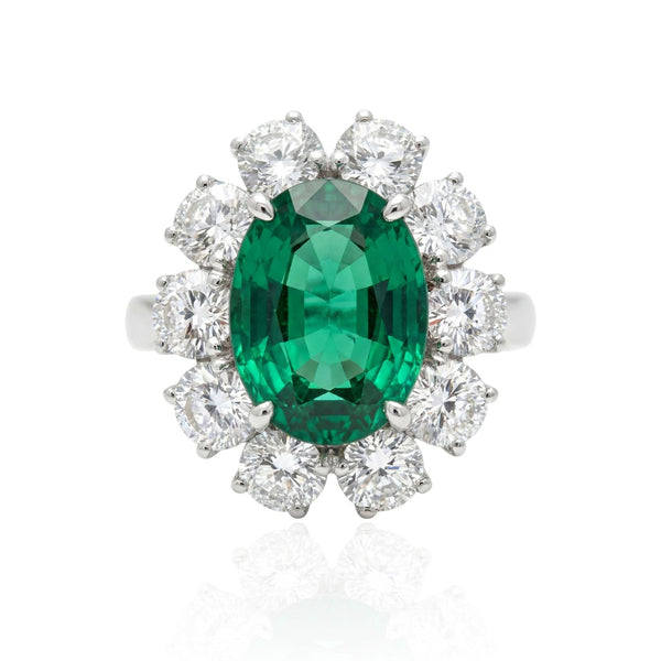 Emerald white gold ring with diamond accents on a white background