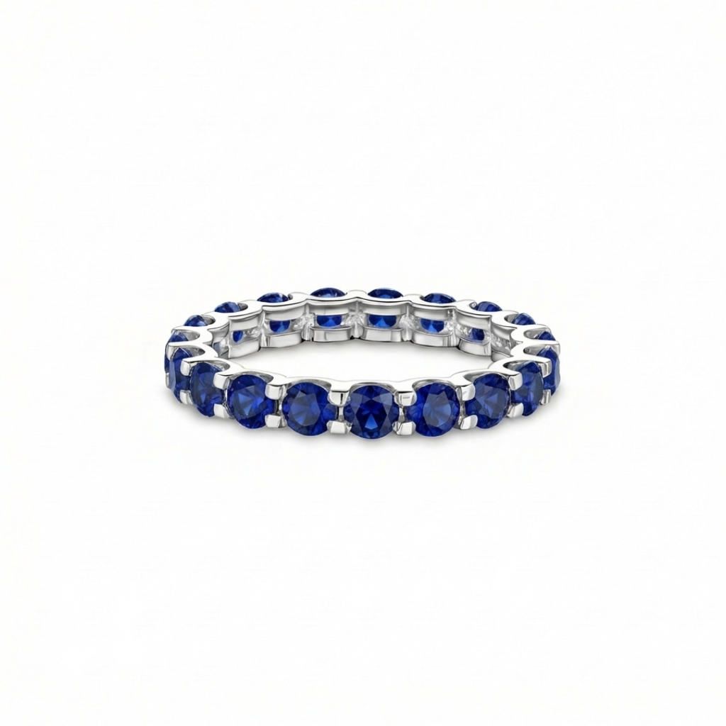 white gold full eternity ring with blue sapphires; the ring is presented on a white background
