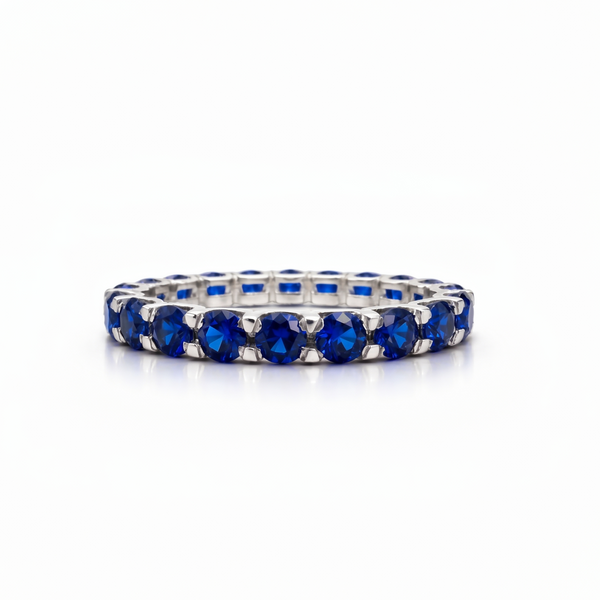 White gold eternity ring with blue sapphires on a white background