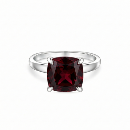 white gold ring with a dark red ruby - garnet tone on a white background