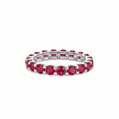 White gold eternity ring with red lab grown ruby on a white background